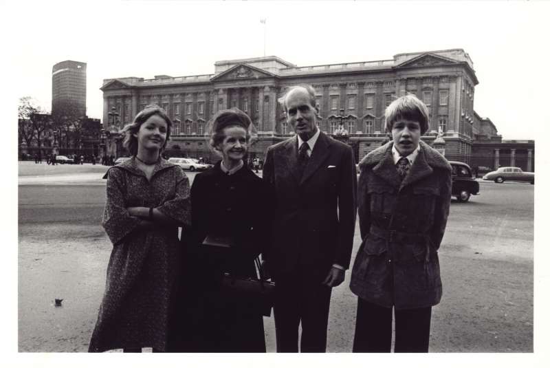 Shot of a teenage Elizabeth and Jeromy with Sue Ryder and Leonard Cheshire, with Buckingham Palace in the background