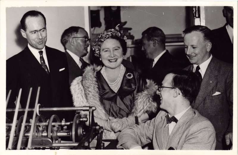Close up of HM the Queen Mother smiling with Leonard Cheshire next to a printing press