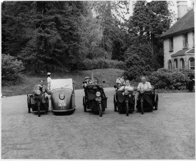 Five men in adapted motorcycles outside the old Le Court building