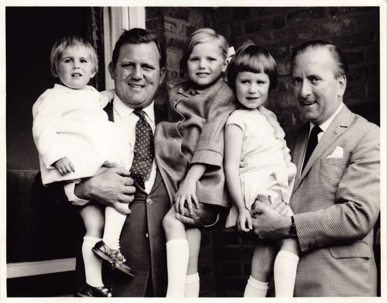 Close up of two men holding three young children