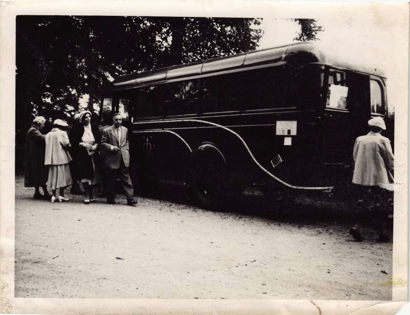 Group of people standing next to a bus
