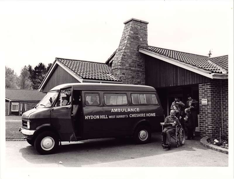 Photo of the ambulance or minibus used by residents at Hydon Hill, with a resident in the foreground