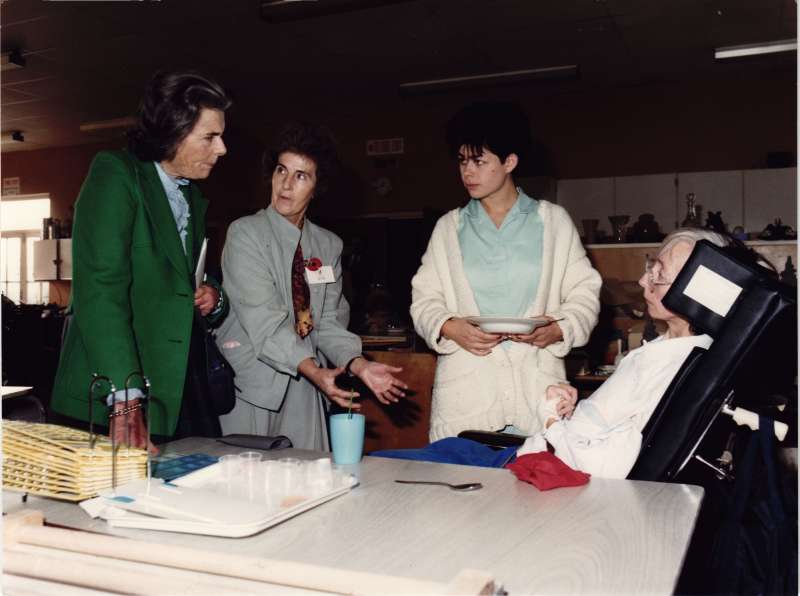 Countess Mountbatten of Burma and two staff members talking to a female resident in a wheelchair