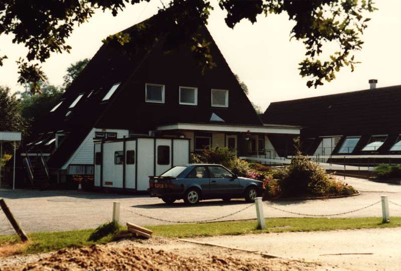 Colour photograph of the exterior view and driveway at Chipstead Lake