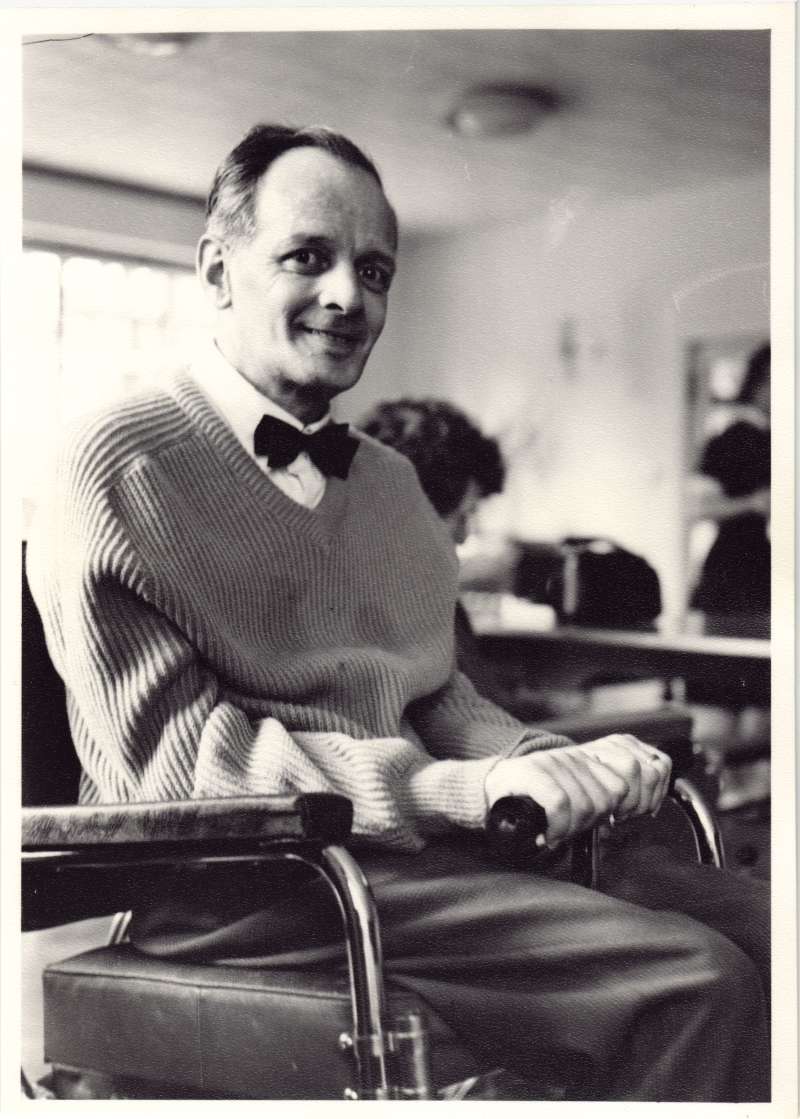 Close up of a man in a wheelchair wearing a bow tie looking at the camera