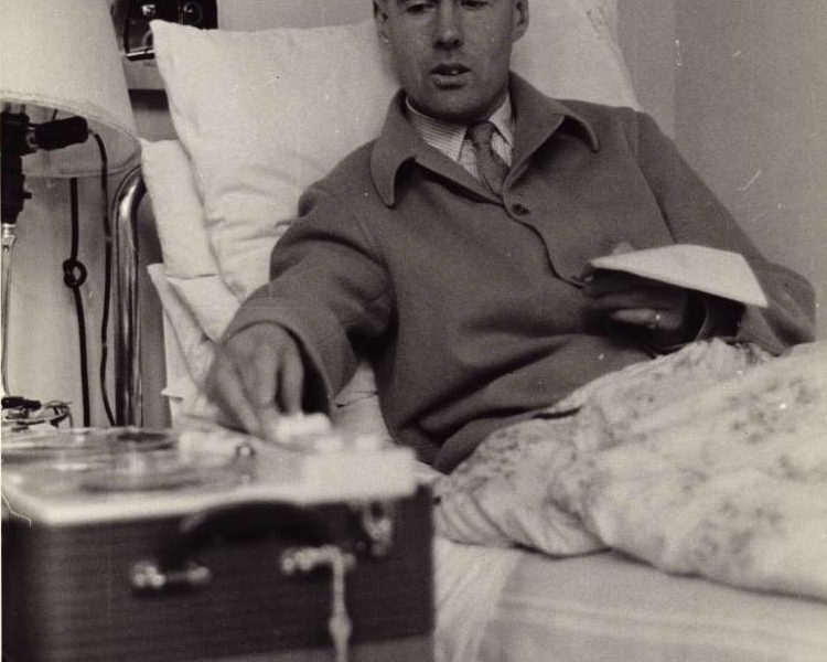 Leonard Cheshire sat up in a hospital bed